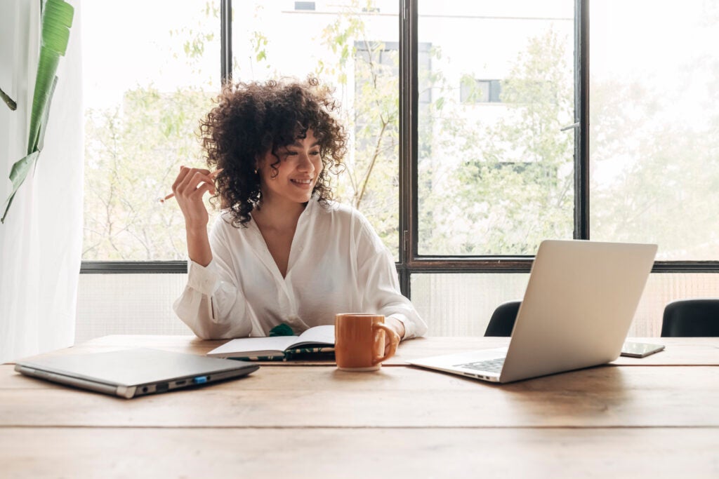 HR Professional Watching Webinar and Smiling